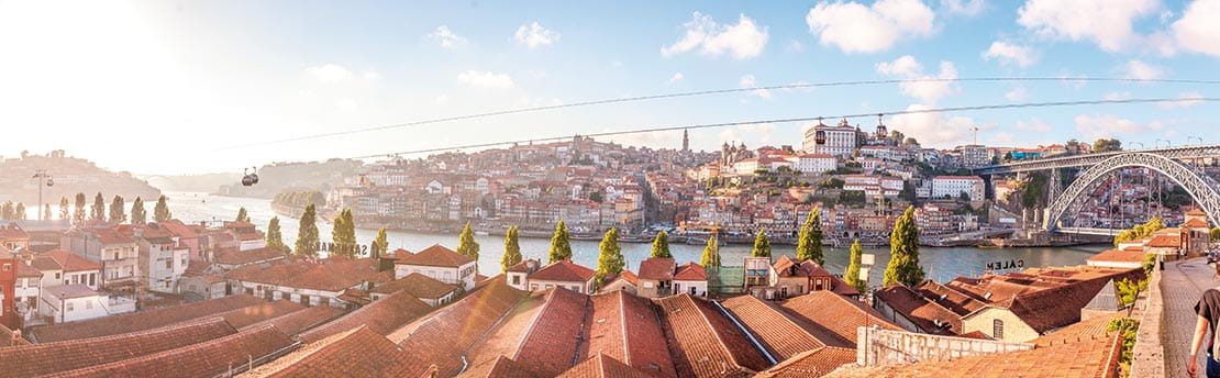 A view over the rooftops of Oporto beside the Douro River at dusk